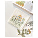 Sample project from the book showing yellow flowers on white fabric next to a gardening book.