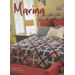 Image of a twin bed with a colorful quilt in blue and red patterns, featuring decorative pillows.