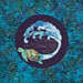 A quilt featuring a turtle near a stylized wave against a blue and green patterned background.