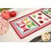 A stylized shot of the completed sew cute runner on a white dresser with apples and floral décor. 