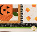 A super close up shot of the corner of the patchwork block intersecting with the laser cut scallop border and scattered candy corn, demonstrating piecing and stitching detail. 