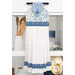 The completed white Hanging Towel, colored in blue and white fabrics from the Penelope collection by Riley Blake Designs, hung on a white kitchen drawer and staged with coordinating flowers and kitchen utensils.