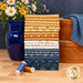 A stack of the fabrics included in the Denim & Daisy collection, with a vase with daisies and oval boxes and a denim cloth and thread.