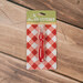 The Un-Stitcher by Lori Holt in red gingham packaging on a wooden background
