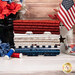Stack of red, white, and blue Fat Quarter fabrics in front of patriotic flowers, an American flag, and threads.
