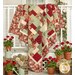 The completed Easy as ABC and 123 quilt kit - Ambiance, draped over a white porch surrounded by red geraniums. 