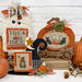A collection of Halloween cross stitch displays, including a witch hat, pumpkins, and candy.