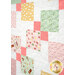 An angled image of the quilt, showing fabric print and details as well as top quilting effects. 