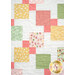 A close up image of the quilt, demonstrating fabric colors and print details as well as patchwork design.