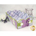 The completed Scalloped Basket, colored in periwinkle blue and purple florals fabrics from the Hydrangeas in the Garden collection by Riley Blake Designs, staged on a white table with coordinating flowers and décor.