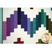 A closeup on the patchwork on the quilt, demonstrating fabric color and print details.