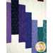 A super closeup on the patchwork on the quilt, demonstrating fabric color and print details.