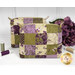 The two completed Mini-Charm Bags, colored in elegant green and purple fabrics from the Collection for a Cause: Essence collection by Moda Fabrics and staged on a white countertop, surrounded by coordinating threads and décor. A gold Shabby Fabrics logo is in the bottom right corner.