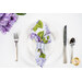 A shot of one of the napkins with the floral print faced out, staged on a white plate with a brushed nickel napkin ring.