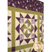 A close up on the patchwork of the quilt, demonstrating details on the fabrics, piecing, and top quilting.
