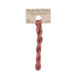 A skein of dusty rose pink embroidery floss, twisted and bundled, with a tan label featuring the brand name and color information.
