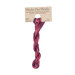 A skein of variegated hot pink and plum embroidery floss, twisted and bundled, with a tan label featuring the brand name and color information.
