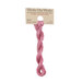 A skein of variegated light and dark pink embroidery floss, twisted and bundled, with a tan label featuring the brand name and color information.