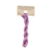 A skein of light pink and purple embroidery floss, twisted and bundled, with a tan label featuring the brand name and color information.
