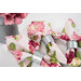 A stylized close up on the pink napkins, showing fabric detail as coordinating flowers peek into frame from the upper left corner.