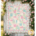 The completed Easy as ABC Quilt Kit in pastel pink, blue, and white fabrics from the Charlotte collection by Clothworks, hung on a rustic white fence with pink roses.