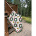 Image of the quilt draped over a wooden porch railing 