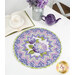 A round table topper with a bursting star design in periwinkle and lilac fabrics with blooming purple hydrangeas at the center placed on white table next to a teapot and cup and a bouquet of flowers. 