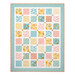 The completed Charming Windows Quilt colored in pastel primary colors from the Rainbow Dreams collection by Wilmington Prints, isolated on a white background.