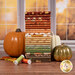 A stack of the fabrics included in the Cozy Autumn Collection, with pumpkins and a window and leaves and thread.