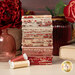 A stack of the fabrics included in the Fat Quarter Bundle of the Le Jardin Rouge collection, with jars and vases and books and flowers and thread.