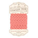 Coral pink ric-rac trim on ins cardboard packaging, isolated on a white background.