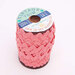A wooden spool with large coral pink ric-rac trim on a white background