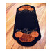 Black felt runner decorated with orange pumpkins and green vines on a wooden surface.