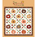 Digital mockup of the Cozy Autumn quilt featuring patchwork pumpkins, falling leaves, and hearts, set against a warm brown background with a logo at the top.