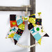 Colorful patchwork bow with animal motifs, hanging on a wooden hook with a beaded circle below.