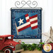 The completed paper pieced flag project in red, white, and blue fabrics, displayed on a craft stand and staged with a vintage red truck and a star.