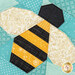 A close up on the paper pieced bee, showing details on the fabrics including the gold glitter wings.