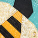 A super close up on the paper pieced bee, showing details on the fabrics including the gold glitter wings.