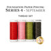 Four spools of red, pink, medium and dark green thread, isolated on a white background. 