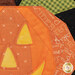 A super close up on the jack-o'-lantern, showing fabric color and print details as well as top stitching effects.