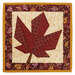 The completed Foundation Paper Piecing Series 4 November project, featuring a maple leaf in warm rust red, mahogany, and cream prints, isolated on a white background. 