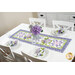 The completed Patchwork Table Runner colored in periwinkle fabrics from the Hydrangeas In The Garden collection from Riley Blake Designs, staged on a white table with coordinating table settings and flowers.