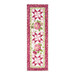 The completed Patchwork Table Runner colored in pink fabrics from the Hydrangeas In The Garden collection from Riley Blake Designs, isolated on a white background.