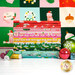 A stack of the fabrics included in the Merry Happy collection, with the panel in the back and ornaments and thread.