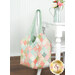The completed Mondo Bag, colored in soft pastels from the Sunbonnet collection by Moda Fabrics and hung on the back of a white chair next to a white table, staged with coordinating décor.