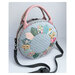 The completed Carry Round bag, a circular design featuring a quilted surface, a dresden plate flower, dual handles, and a cross body strap.