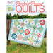 The front of the Perfect Precut Quilts Book showing a finished quilt draped over a fence in a grassy field and the book title in red across the top.
