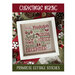 Front of the Christmas Magic pattern showing the completed design framed and staged with coordinating decor.