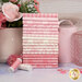 A stack of the fabics included in the Sweet Pink collection, with a vase and pink containers and flowers and buttons and thread.