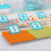 Colorful fabric samples with clips labeled with letters and numbers, arranged on a table for selection.